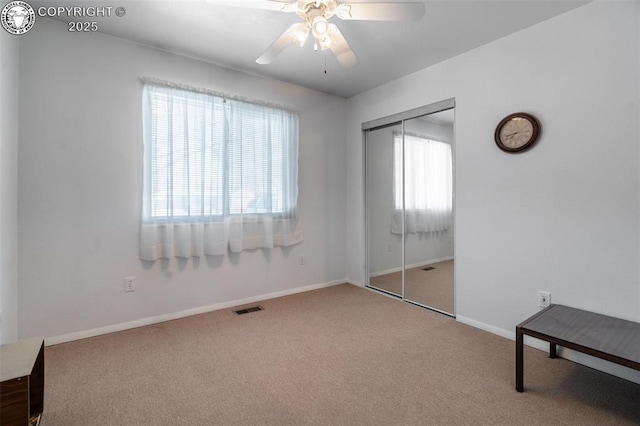 unfurnished bedroom with ceiling fan, carpet, and a closet