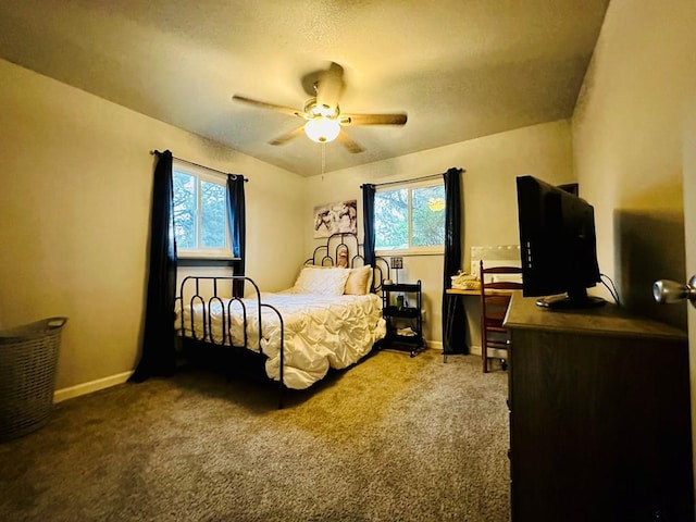 carpeted bedroom featuring multiple windows and ceiling fan