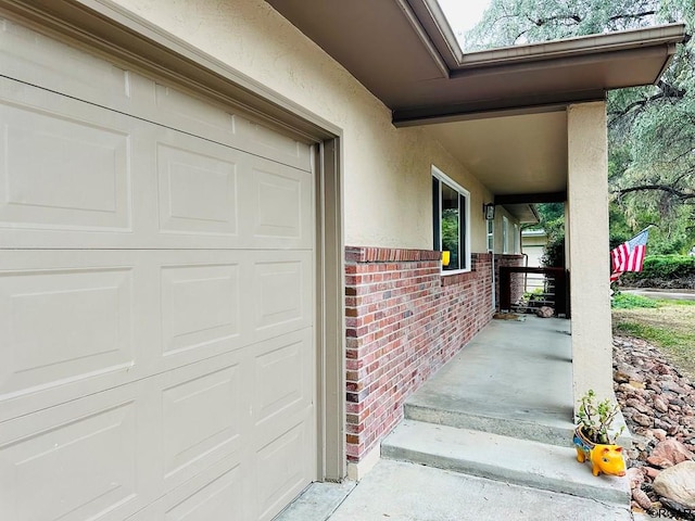 doorway to property featuring a garage and a porch