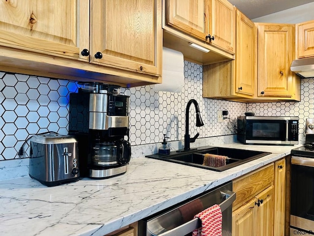 kitchen with tasteful backsplash, appliances with stainless steel finishes, and sink