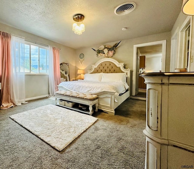 bedroom featuring dark colored carpet and a textured ceiling