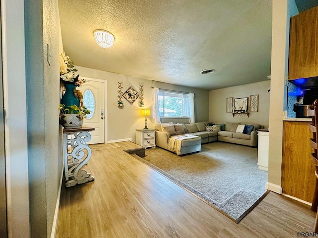 living room with a textured ceiling and light wood-type flooring