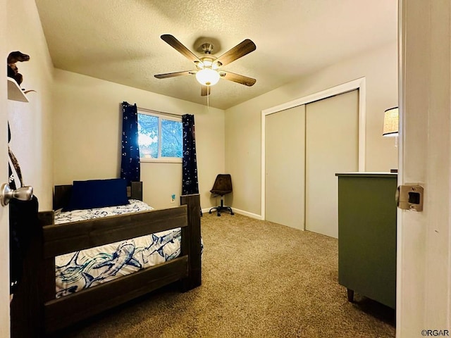 carpeted bedroom featuring a textured ceiling, ceiling fan, and a closet