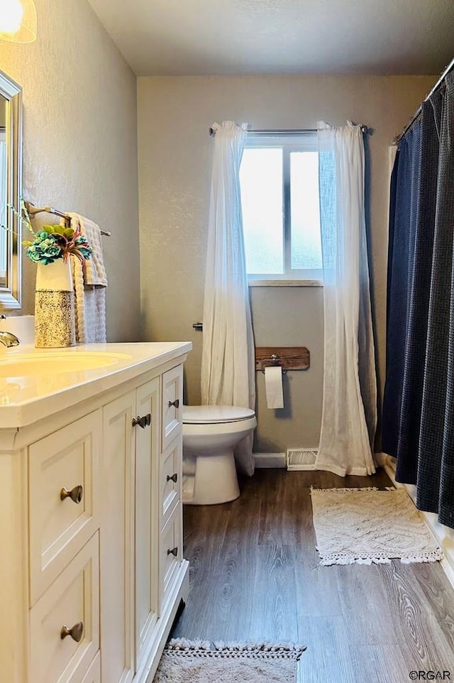 bathroom featuring vanity, hardwood / wood-style floors, and toilet