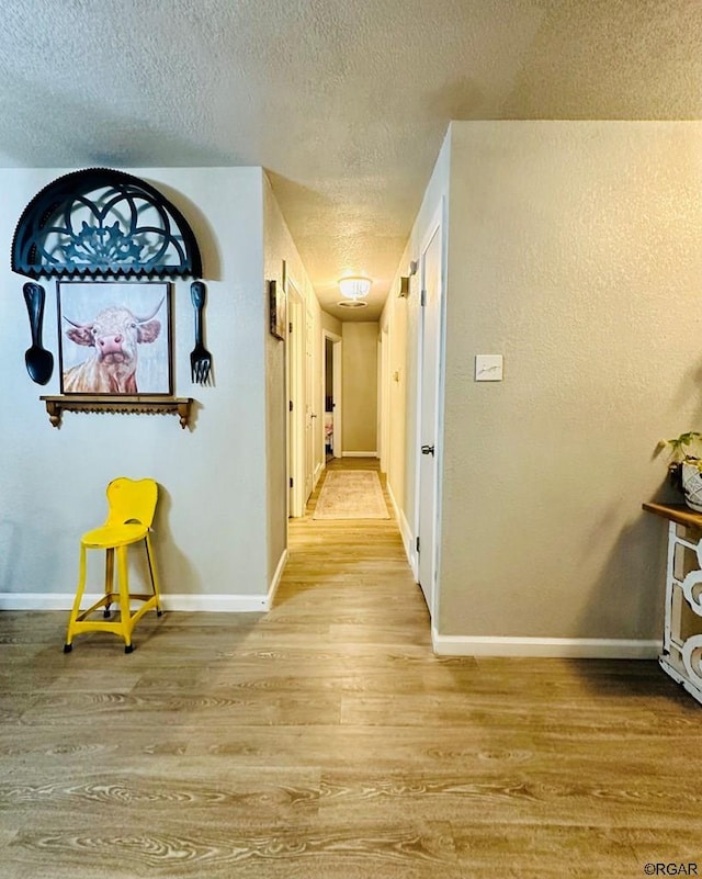 hallway featuring a textured ceiling and light wood-type flooring