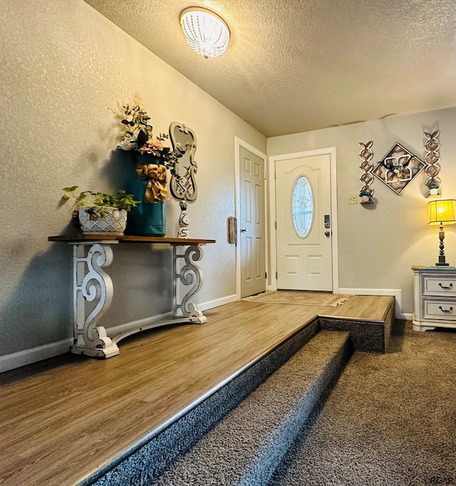 foyer with wood-type flooring and a textured ceiling