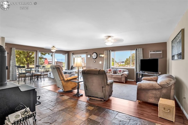 925 2nd St, Penrose, CO 81240 - living area with plenty of natural light, stone tile floors, a ceiling fan, and a wood stove