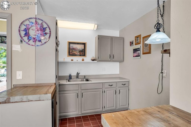 925 2nd St, Penrose, CO 81240 - kitchen featuring gray cabinetry, butcher block countertops, dark tile patterned floors, and hanging light fixtures