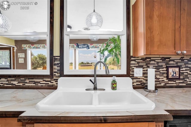 925 2nd St, Penrose, CO 81240 - kitchen view of a chandelier, decorative backsplash, light countertops, hanging light fixtures, and brown cabinetry