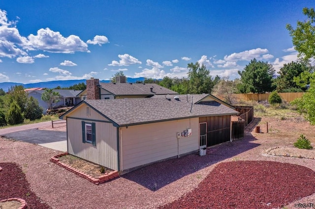 view of side of property featuring a mountain view, a patio, and central air condition unit