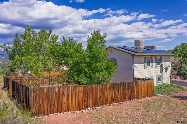 view of home's exterior with central air condition unit and solar panels