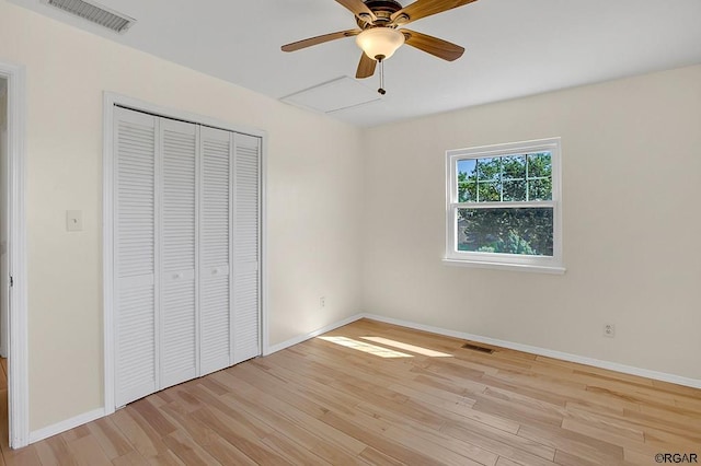 unfurnished bedroom featuring ceiling fan, a closet, and light wood-type flooring