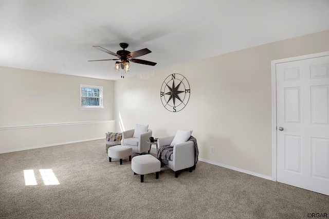 sitting room with ceiling fan and carpet