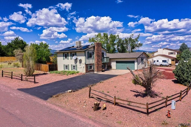 view of front of home with a garage and solar panels