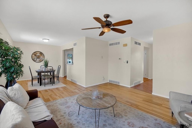 living room featuring wood-type flooring and ceiling fan