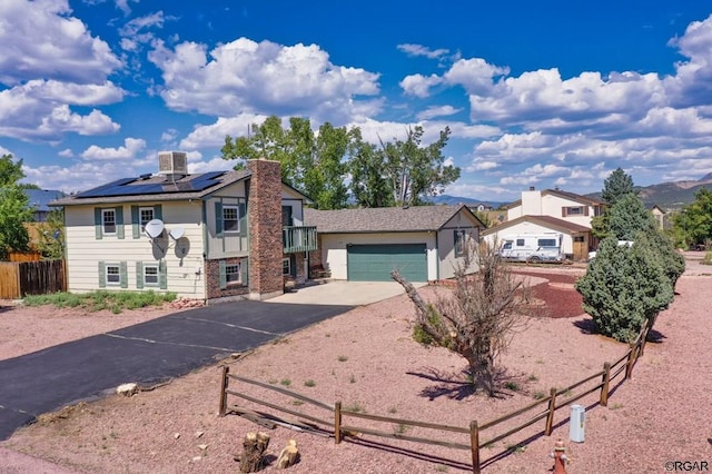 view of front of property with a garage and solar panels