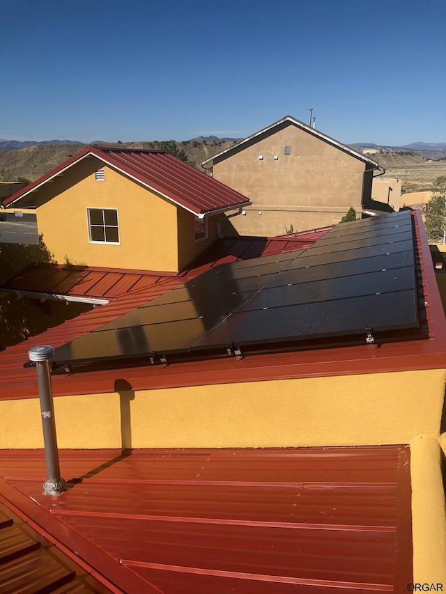 view of property exterior featuring a mountain view and solar panels