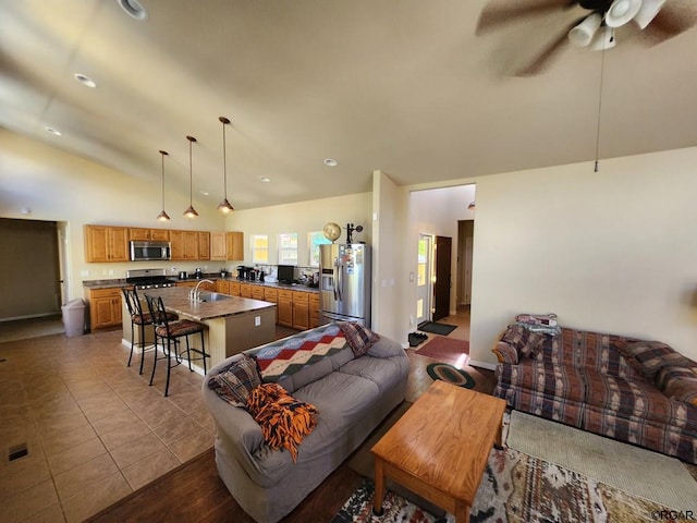 tiled living room featuring lofted ceiling, sink, and ceiling fan