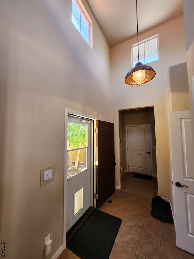 tiled foyer featuring a towering ceiling