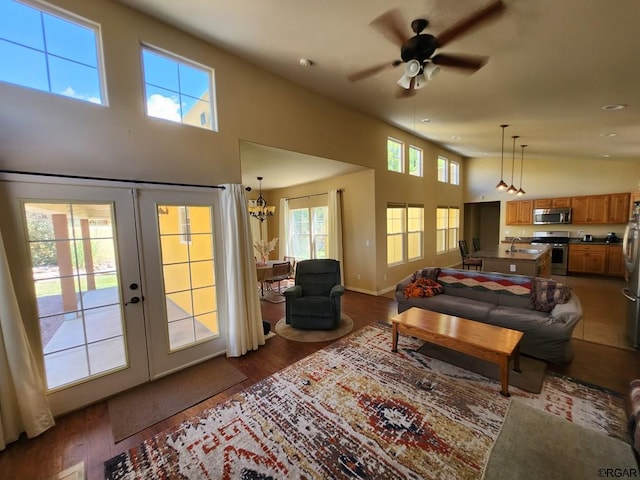 living room featuring french doors, sink, wood-type flooring, a towering ceiling, and ceiling fan with notable chandelier