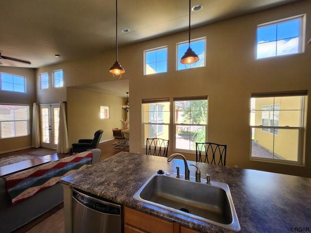 kitchen with sink, decorative light fixtures, stainless steel dishwasher, and french doors