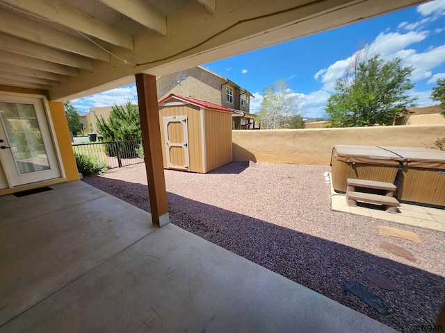 view of patio / terrace featuring a shed and a hot tub