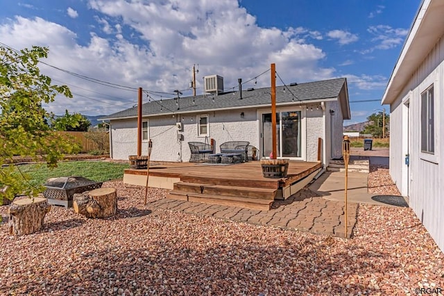 rear view of house with a wooden deck, a patio area, a fire pit, and central air condition unit