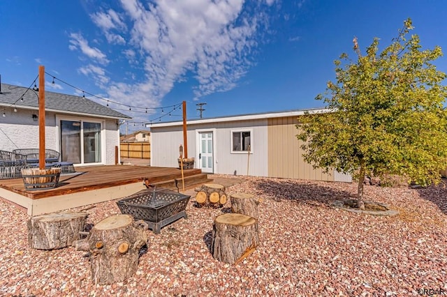 back of house featuring a fire pit and a deck