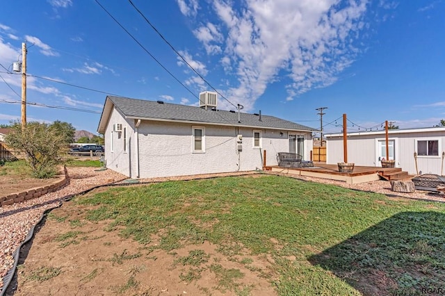 back of property featuring cooling unit, a yard, and a deck