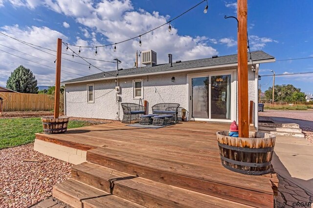 rear view of property with central AC unit and a deck