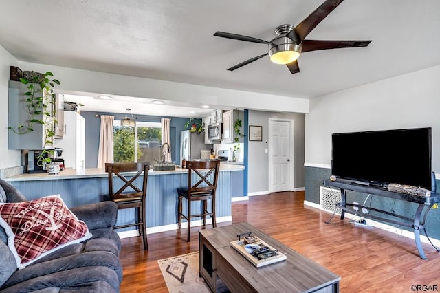 living room featuring hardwood / wood-style floors and ceiling fan