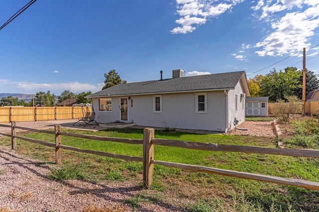 back of property with a storage shed and central AC unit