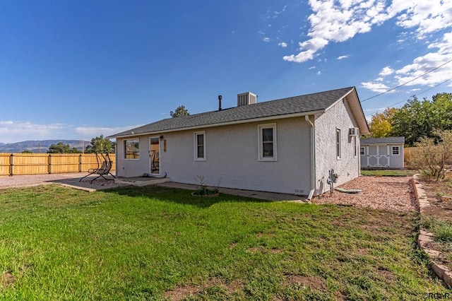 rear view of house with a patio, a yard, central AC unit, and a shed