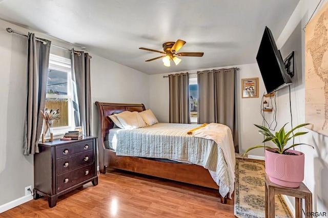 bedroom with multiple windows, ceiling fan, and light wood-type flooring