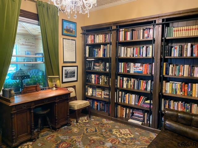 office area with crown molding and a chandelier