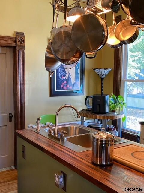 kitchen featuring wooden counters, sink, wood-type flooring, and plenty of natural light