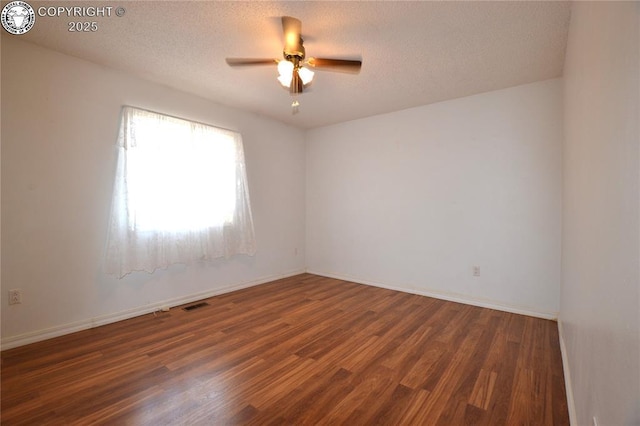 spare room featuring visible vents, a textured ceiling, ceiling fan, and wood finished floors