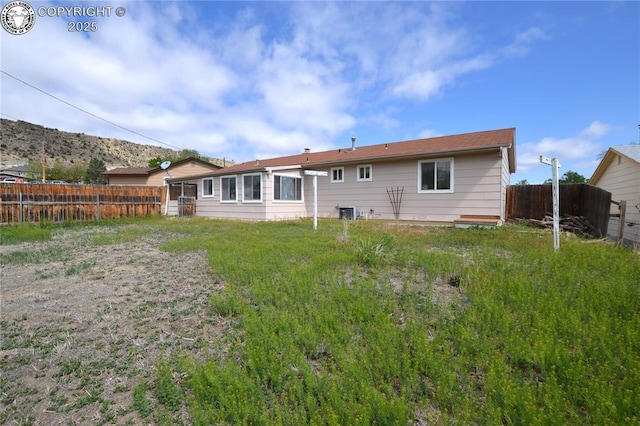 rear view of house featuring fence
