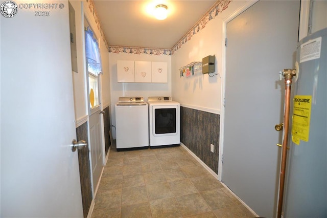 laundry room with washing machine and dryer, baseboards, a wainscoted wall, cabinet space, and water heater