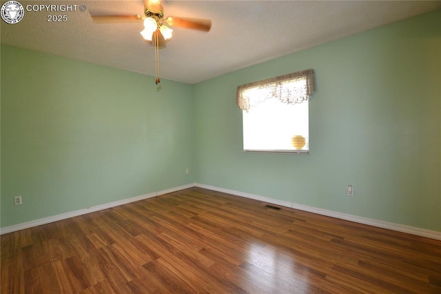 unfurnished room with a ceiling fan, baseboards, visible vents, and wood finished floors