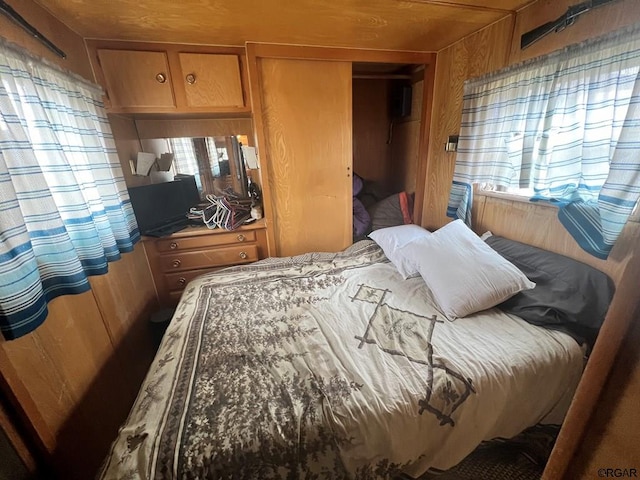 bedroom with a closet and wood walls