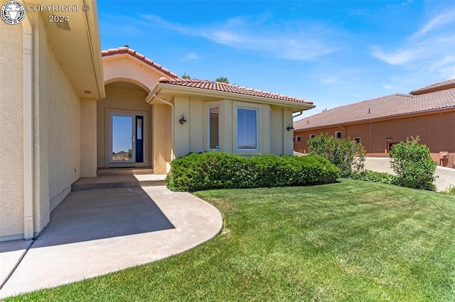 entrance to property with a lawn