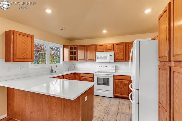 kitchen with sink, white appliances, and kitchen peninsula