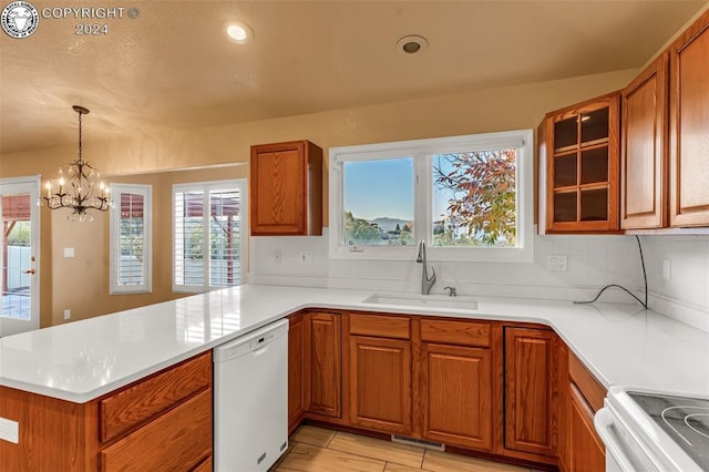 kitchen featuring sink, white appliances, a wealth of natural light, and kitchen peninsula