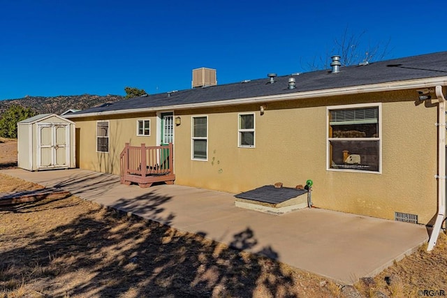 rear view of house featuring central AC, a storage shed, and a patio