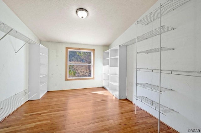 walk in closet featuring hardwood / wood-style flooring and lofted ceiling