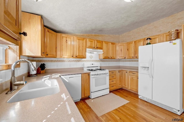 kitchen featuring tasteful backsplash, lofted ceiling, sink, white appliances, and light hardwood / wood-style flooring