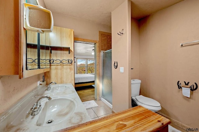 bathroom with sink, a shower with shower door, tile patterned floors, and toilet