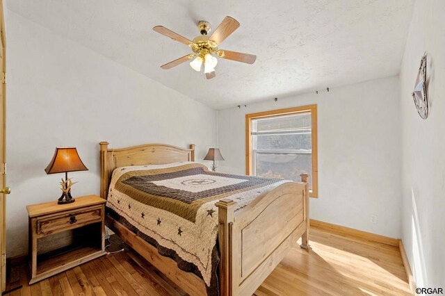 bedroom with light hardwood / wood-style floors and ceiling fan