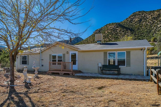 rear view of house featuring central AC, a mountain view, and a patio